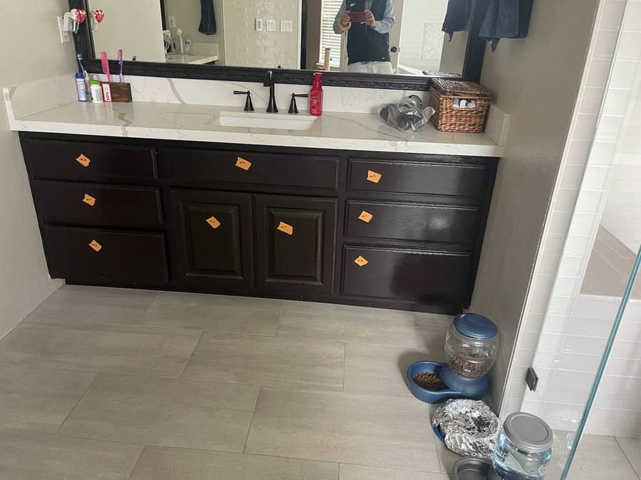 Double vanity with dark cabinets masked for painting
