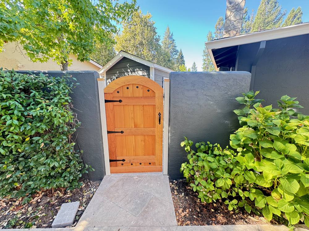Custom wood gate with freshly painted stucco wall