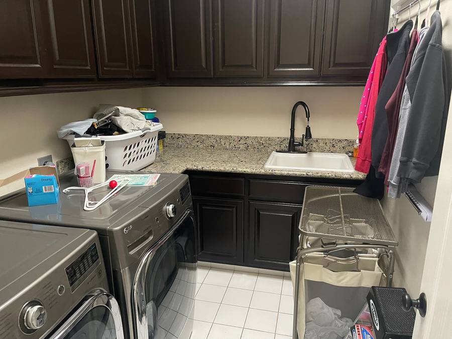 Laundry room with dark brown cabinets before refinishing