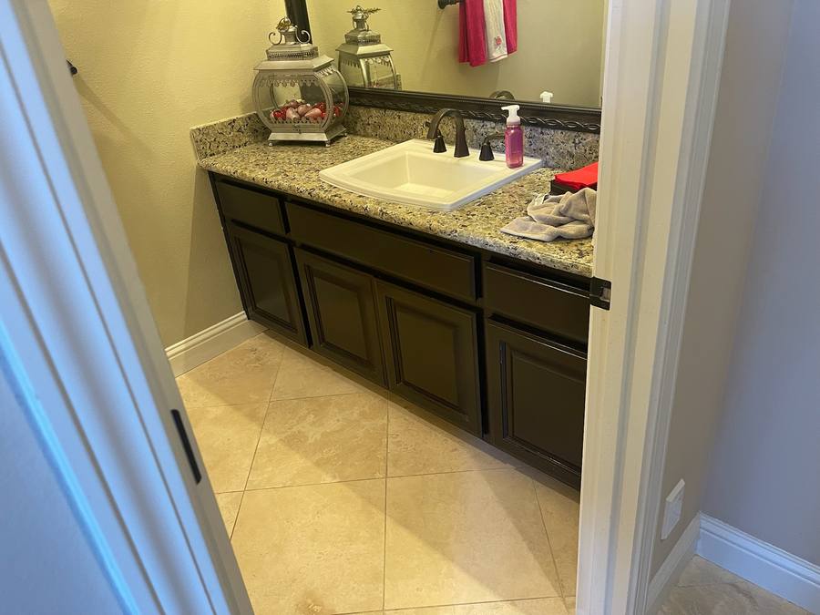 Bathroom vanity with dark brown cabinet before refinishing
